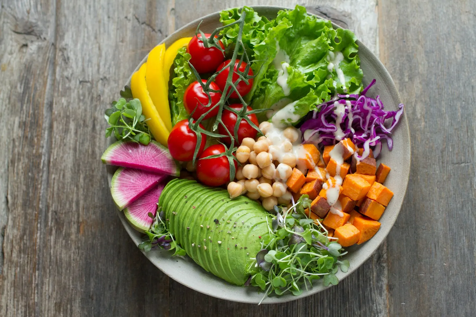 Bol colorat cu legume proaspete, avocado, năut și roșii – mâncare sănătoasă echilibrată